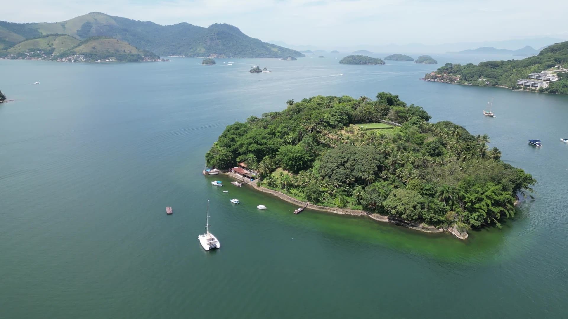 Vista aérea de uma ilha privativa na Baía da Ribeira, Angra dos Reis, com uma embarcação ancorada ao lado